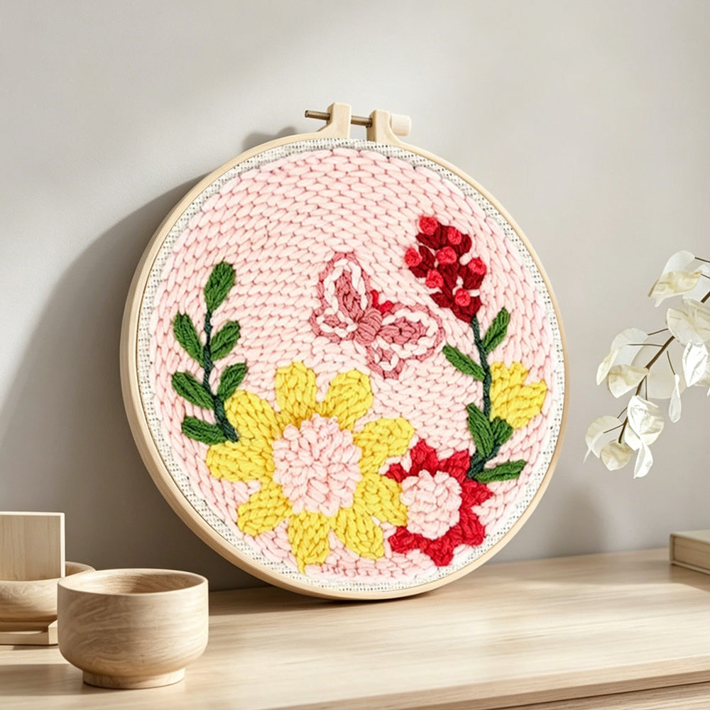 Butterfly and blooming flowers punch needle artwork displayed on a table