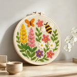 Butterfly, bee and wildflowers punch needle artwork displayed on a table