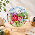 Finished cable car over mountain flowers needle felting displayed on a wooden easel