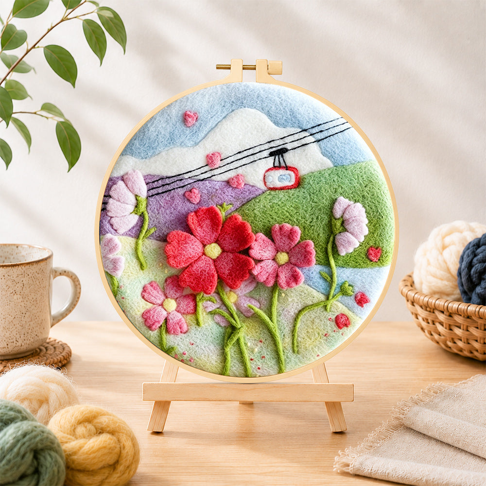 Finished cable car over mountain flowers needle felting displayed on a wooden easel