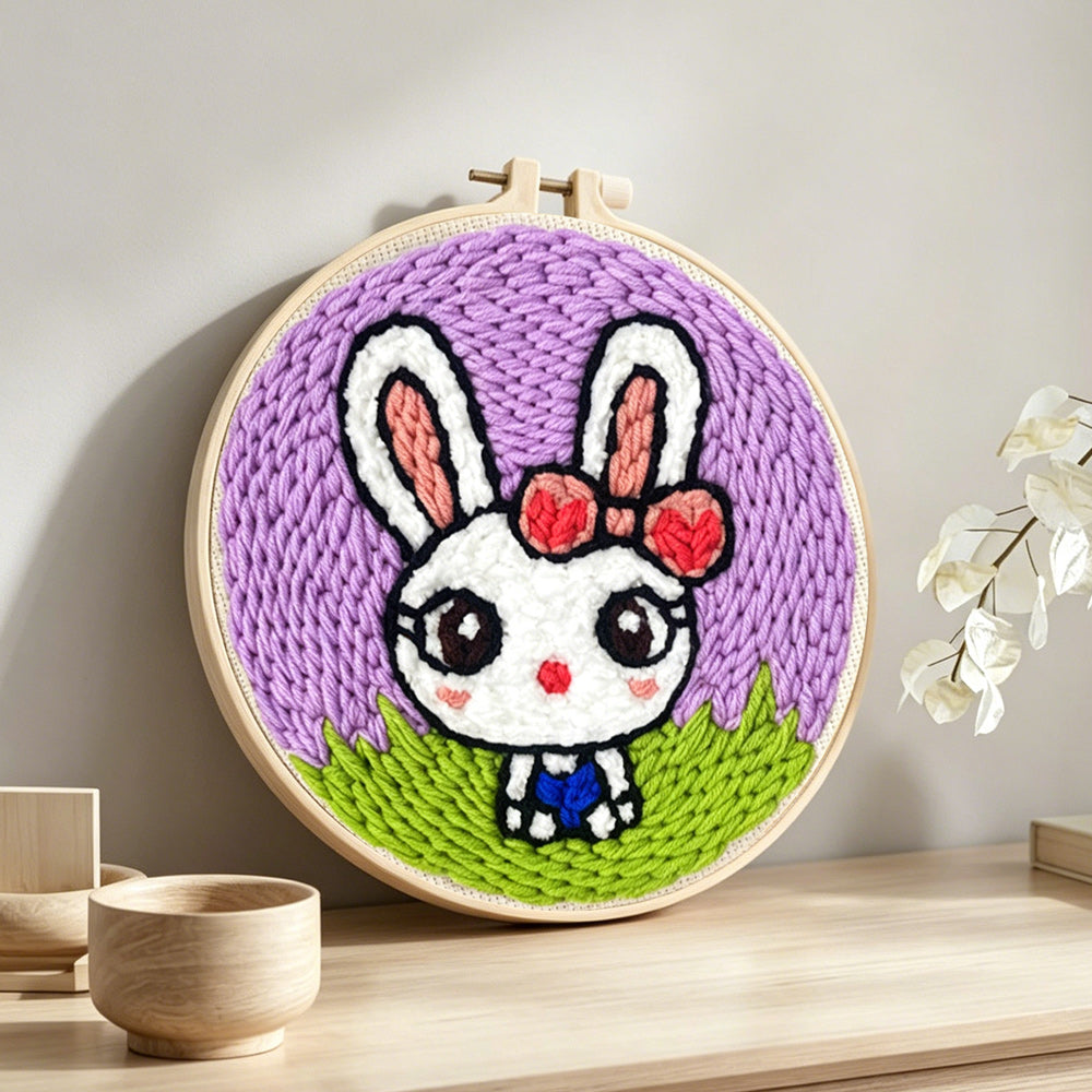Cartoon rabbit on the grass punch needle artwork displayed on a table