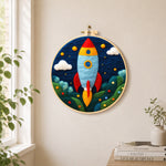 Cartoon rocket launch needle felt wall art displayed in a bright home interior
