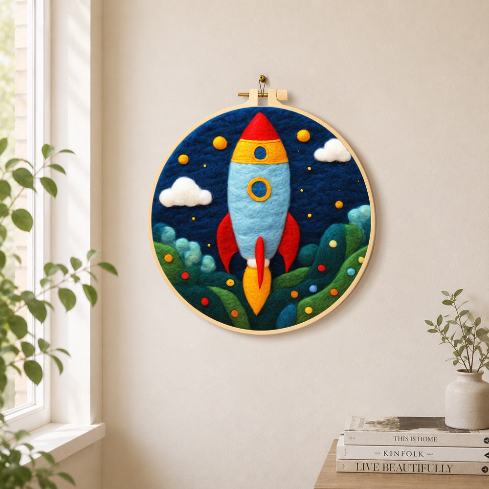 Cartoon rocket launch needle felt wall art displayed in a bright home interior
