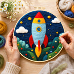 Creating the cartoon rocket launch wool painting by hand with a felting needle