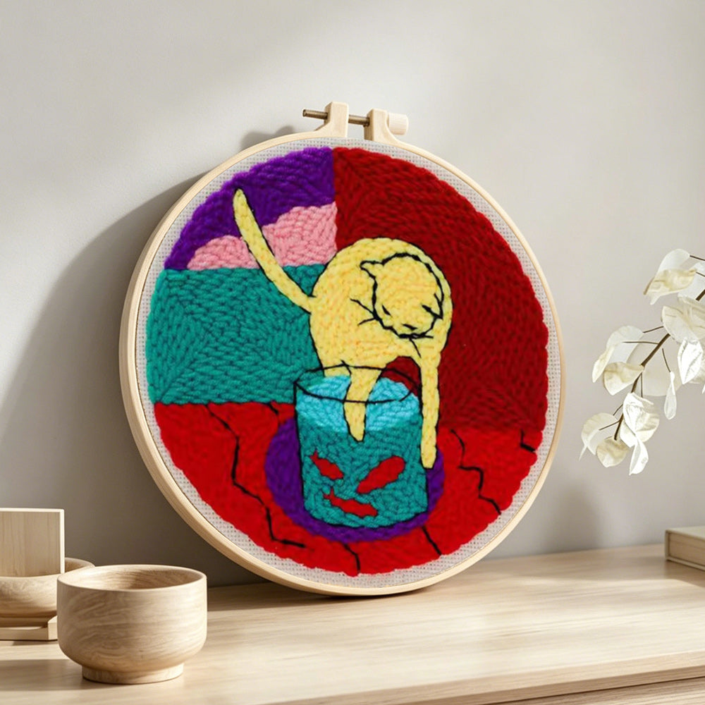 Cat and fish tank punch needle artwork displayed on a table