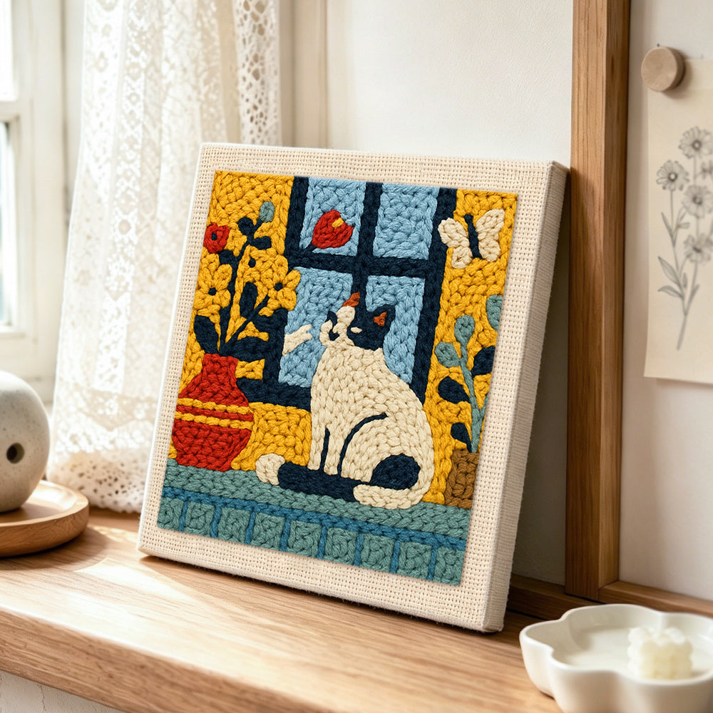 Cat and flower vase on windowsill punch needle artwork displayed on a table