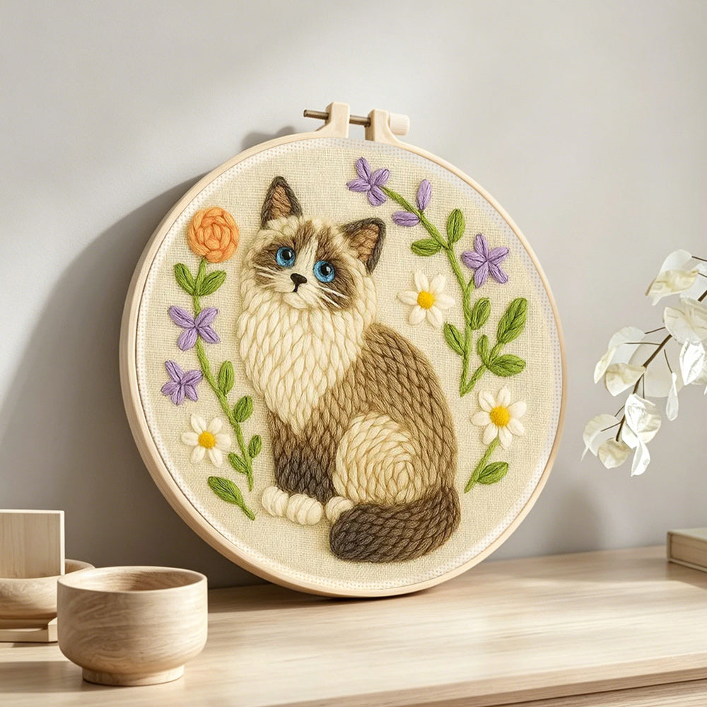 Cat and wildflowers punch needle artwork displayed on a table
