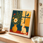 Cat by the window with flower vase punch needle artwork displayed on a table