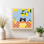 Finished cat peeking at lemon cake artwork displayed on a wall