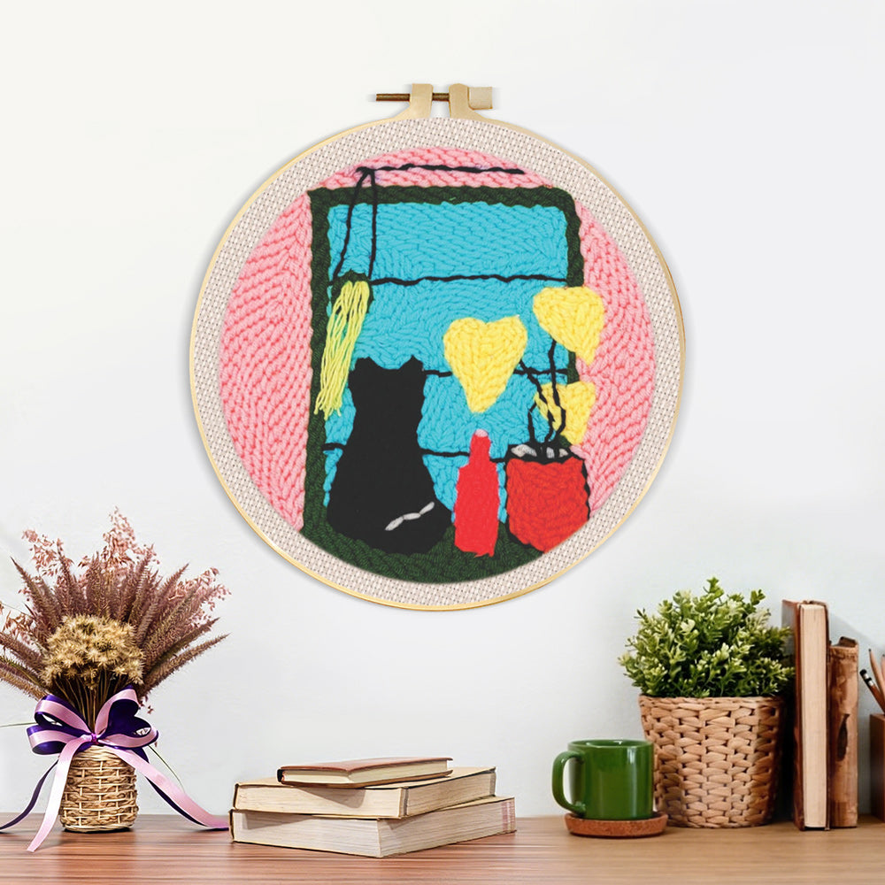 Finished cat silhouette by window with plants and vases artwork displayed on a wall