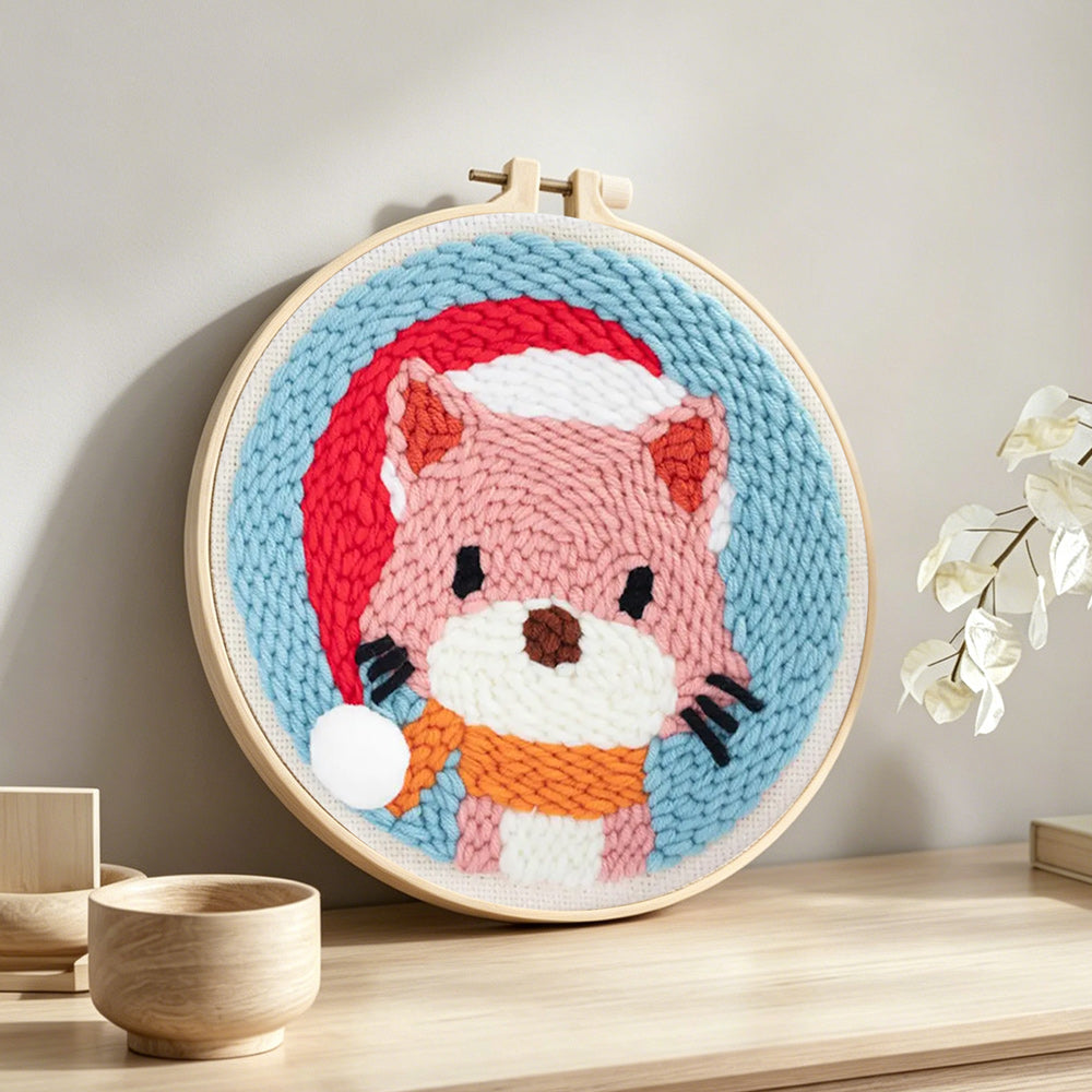 Cat wearing a santa hat punch needle artwork displayed on a table