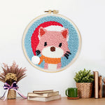 Finished cat wearing a santa hat artwork displayed on a wall