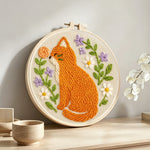 Cat with wildflowers punch needle artwork displayed on a table