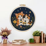 Finished cats and wildflowers under the night sky artwork displayed on a wall
