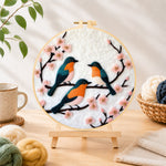 Finished charming birds on pink flower branch needle felting displayed on a wooden easel