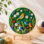 Finished charming flock of colourful birds needle felting displayed on a wooden easel