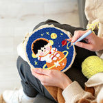 Creating handmade charming space boy on orange planet punch needle artwork