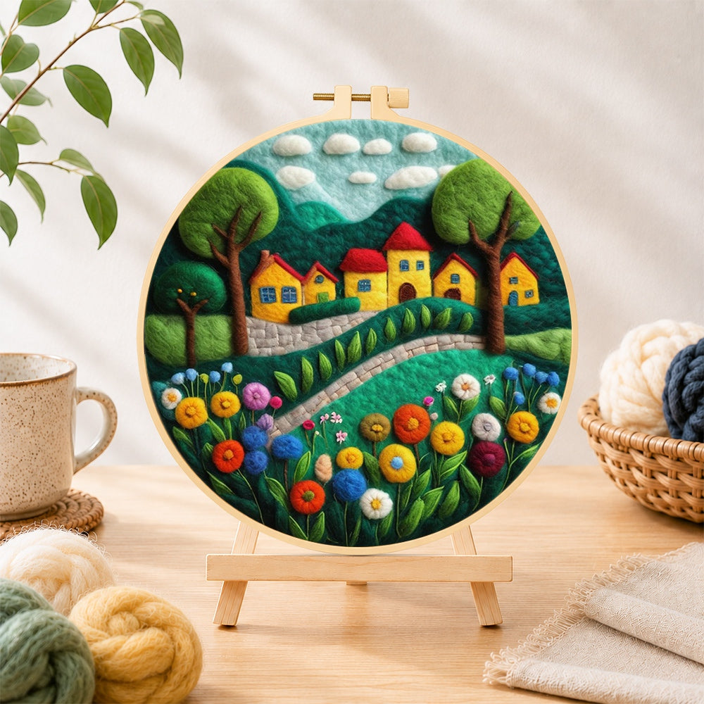 Finished cheerful yellow cottages and blooming flowers needle felting displayed on a wooden easel