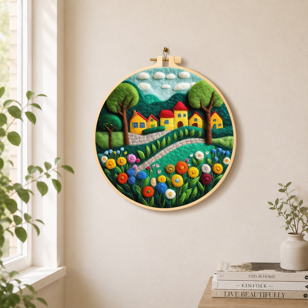 Cheerful yellow cottages and blooming flowers needle felt wall art displayed in a bright home interior