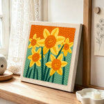 Cheerful yellow daffodils punch needle artwork displayed on a table