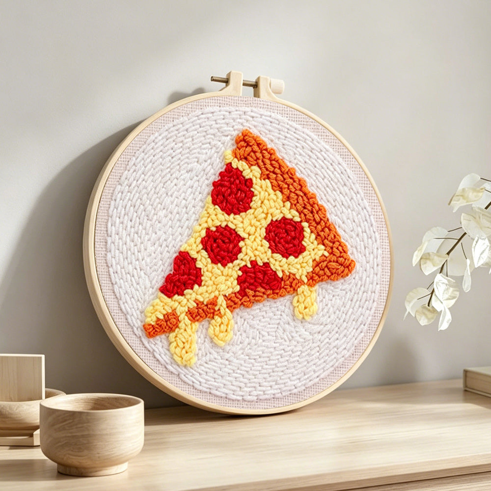 Cheesy pizza slice punch needle artwork displayed on a table