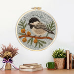 Finished chickadee on berry branch artwork displayed on a wall