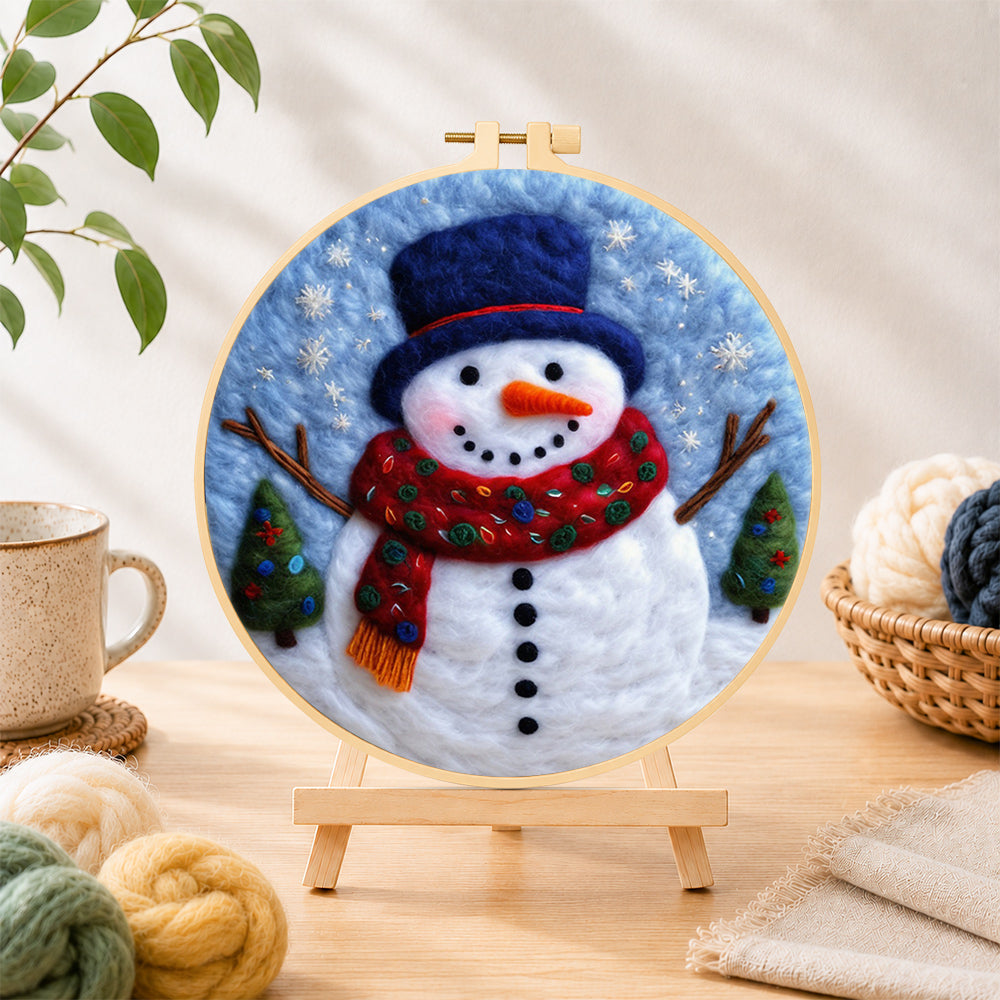 Finished christmas snowman with blue top needle felting displayed on a wooden easel