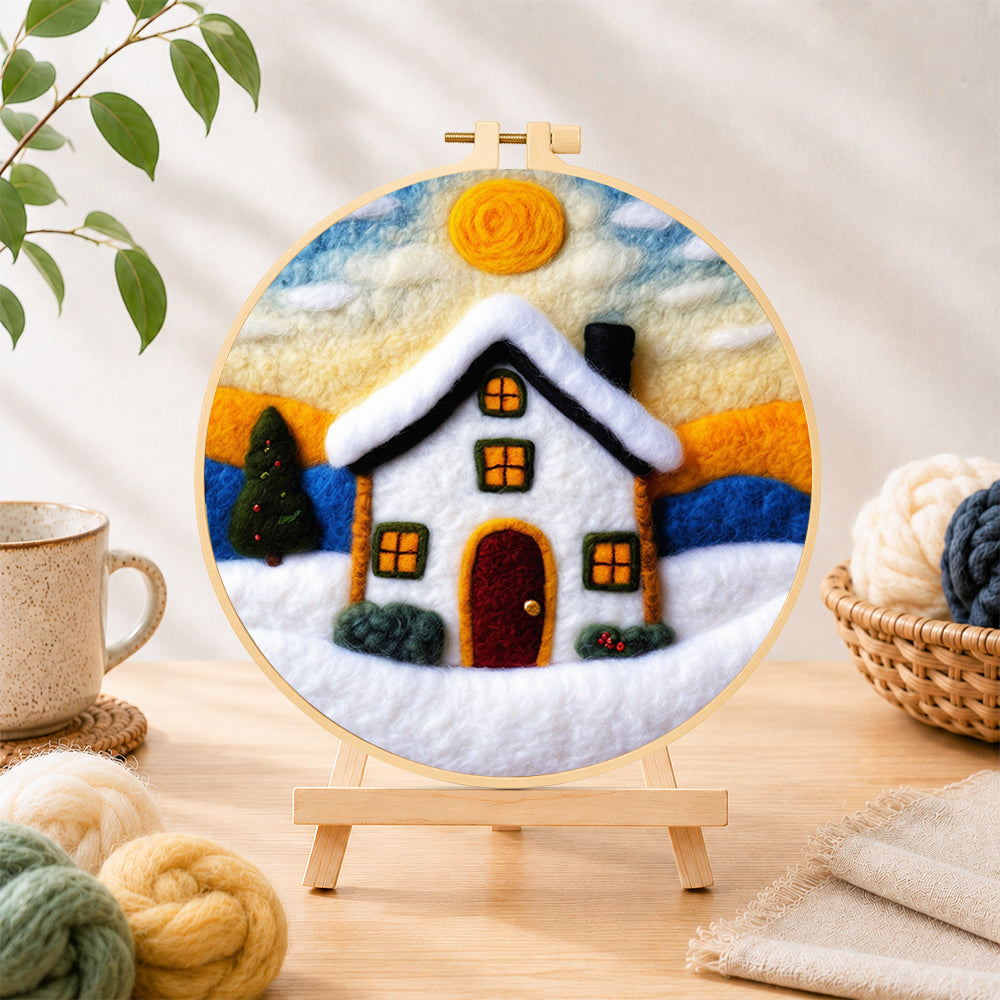 Finished christmas snowy cottage needle felting displayed on a wooden easel