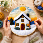 Creating the christmas snowy cottage wool painting by hand with a felting needle