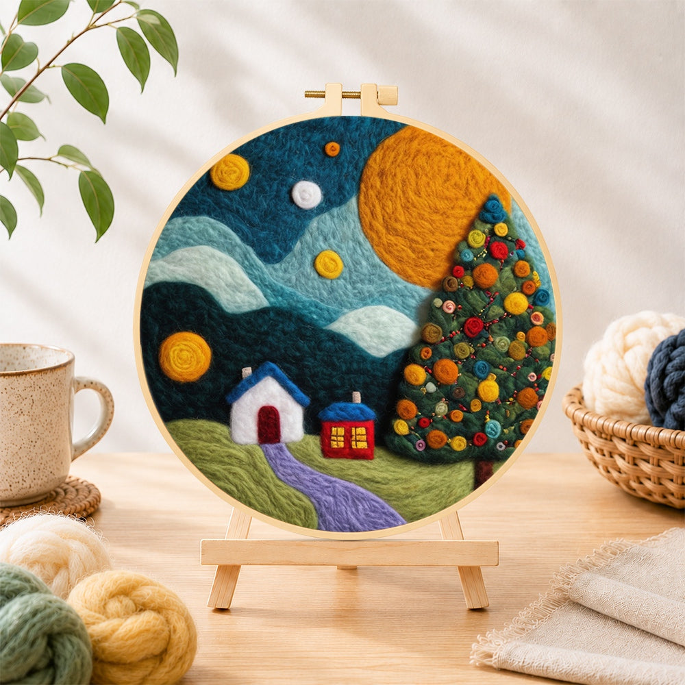 Finished christmas tree and winter village needle felting displayed on a wooden easel