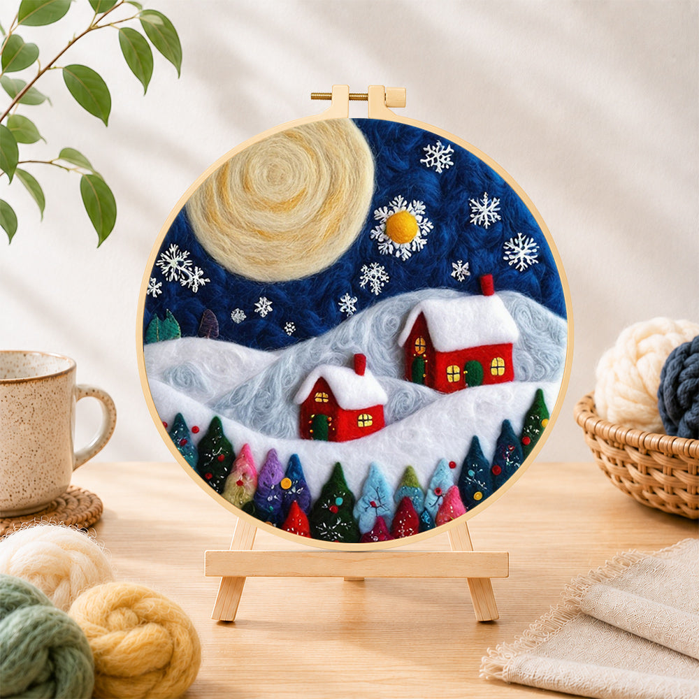 Finished christmas village with big moon needle felting displayed on a wooden easel
