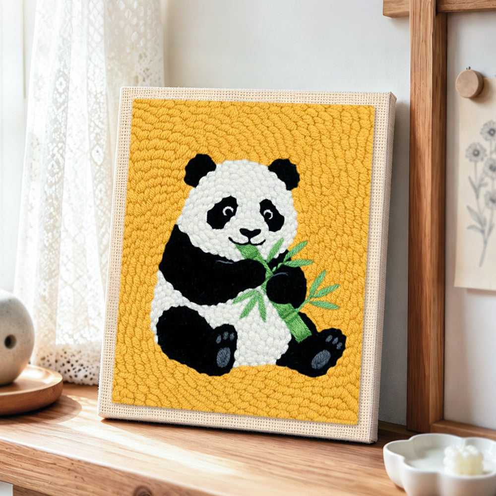 Classic panda eating bamboo punch needle artwork displayed on a table