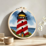 Classic red and white striped lighthouse punch needle artwork displayed on a table
