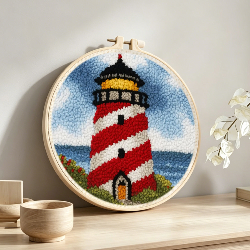 Classic red and white striped lighthouse punch needle artwork displayed on a table