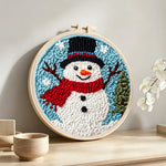 Classic snowman with red scarf punch needle artwork displayed on a table