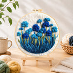 Finished cluster of blue flowers needle felting displayed on a wooden easel