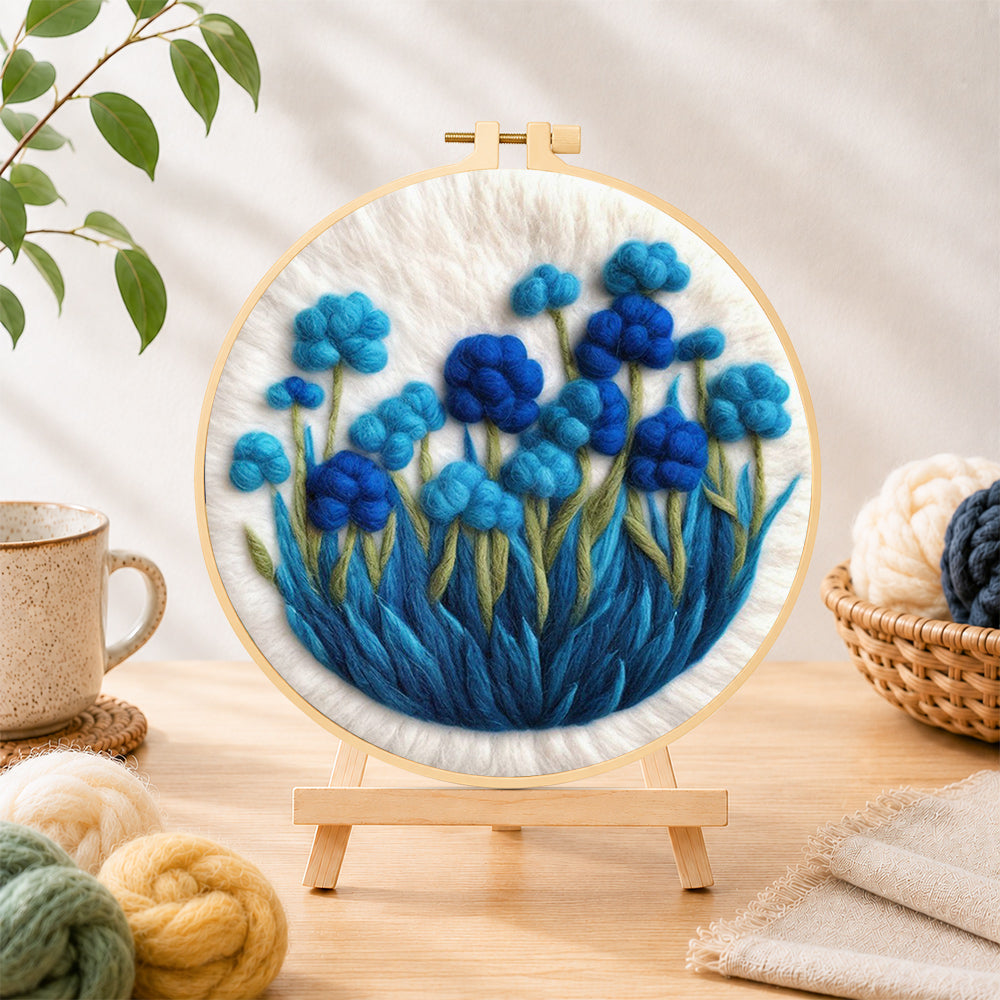 Finished cluster of blue flowers needle felting displayed on a wooden easel
