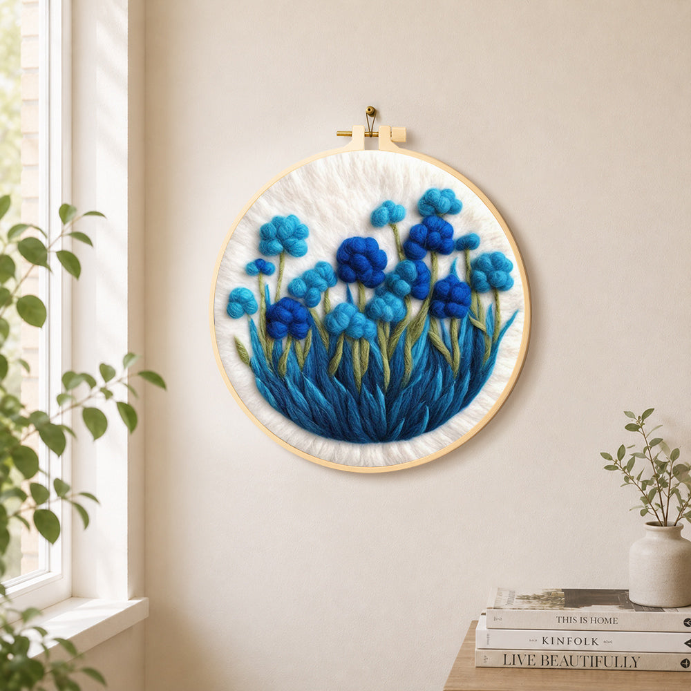 Cluster of blue flowers needle felt wall art displayed in a bright home interior
