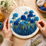 Creating the cluster of blue flowers wool painting by hand with a felting needle
