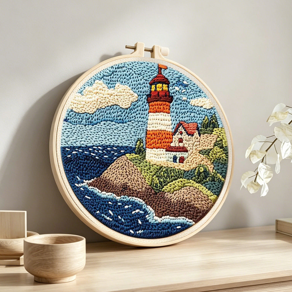 Coastal lighthouse and crashing waves punch needle artwork displayed on a table