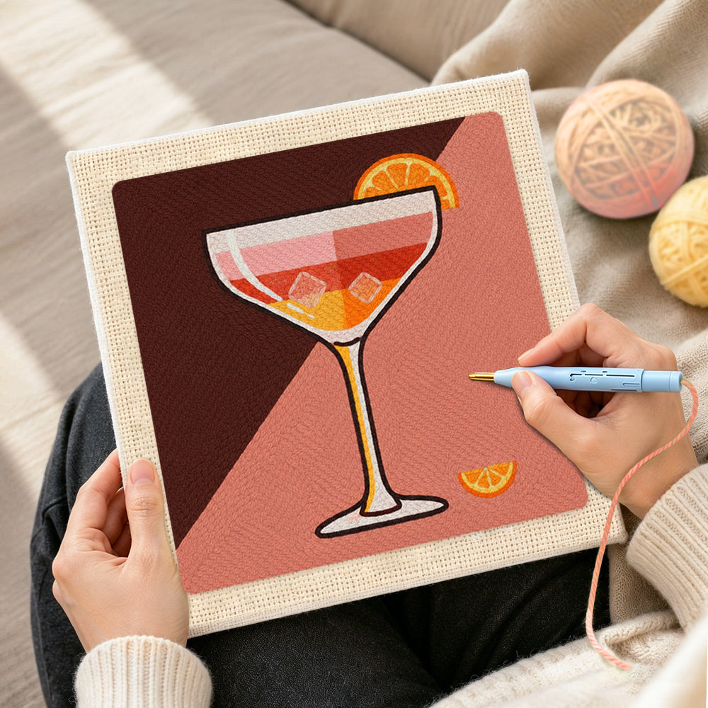 Creating handmade cocktail with ice and orange slice punch needle artwork