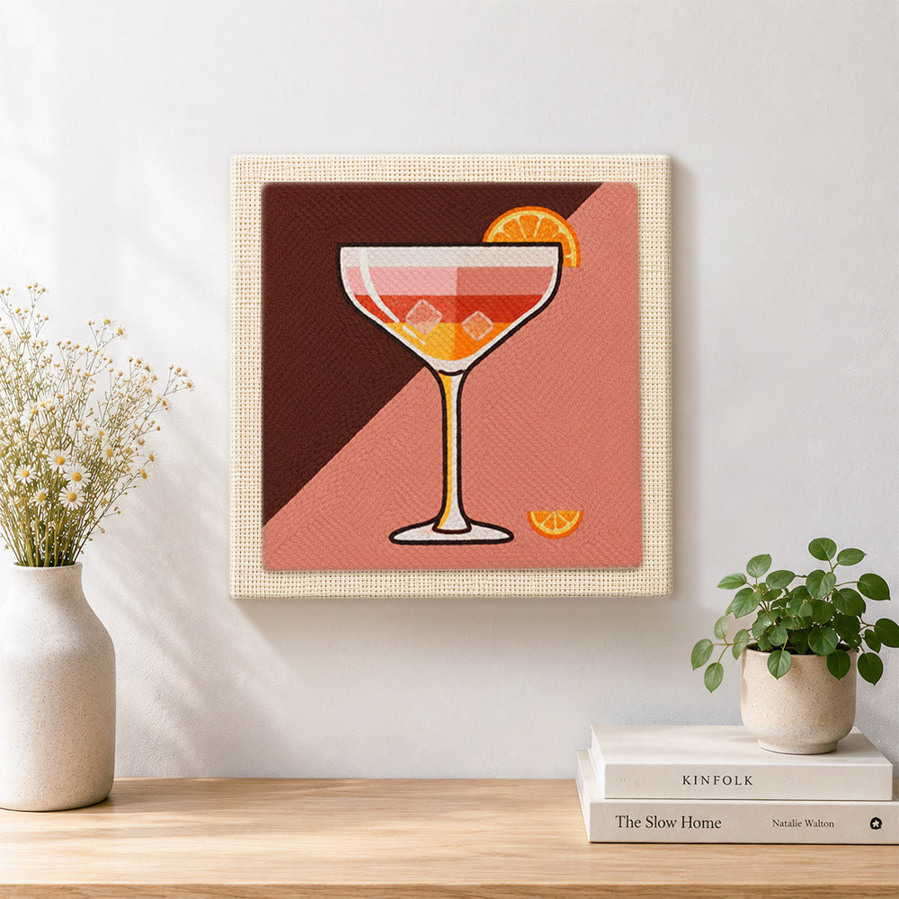 Finished cocktail with ice and orange slice artwork displayed on a wall