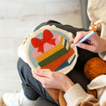 Creating handmade colourful book stack with bow punch needle artwork