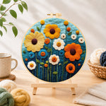 Finished colourful daisies on dark blue needle felting displayed on a wooden easel