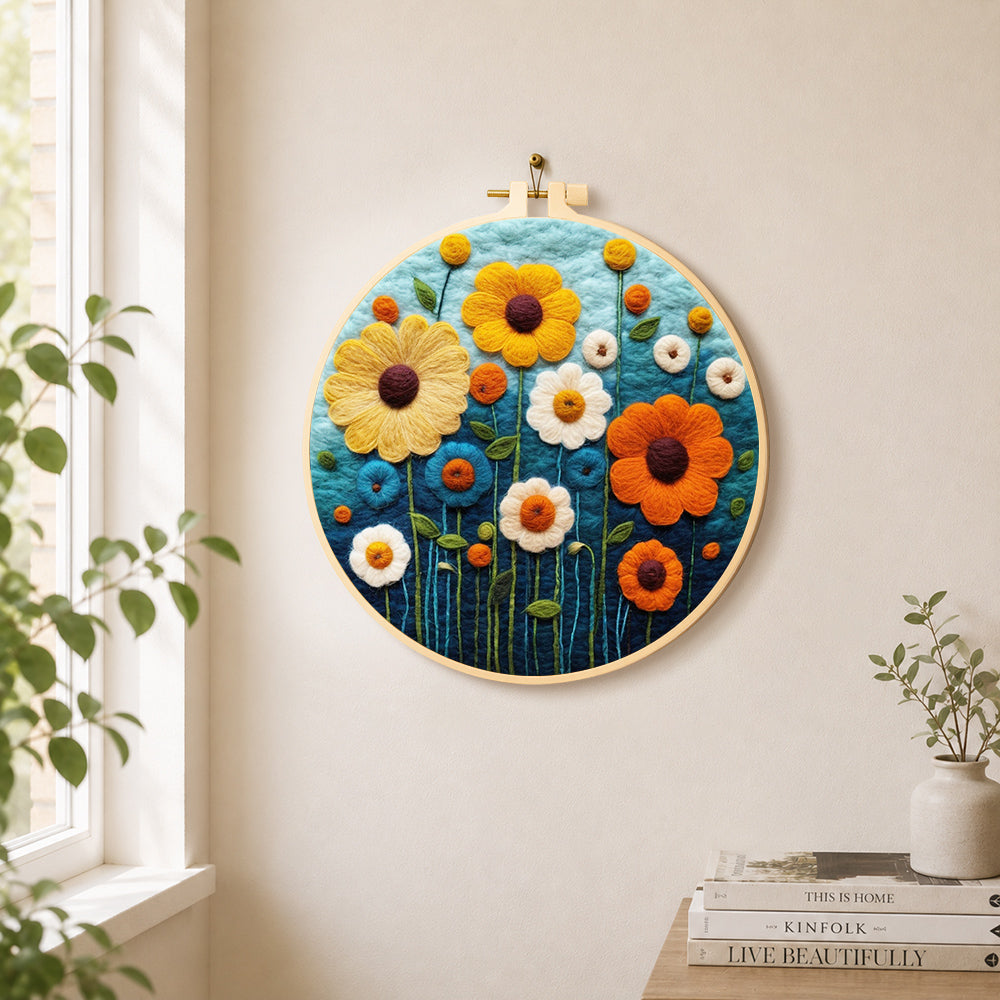 Colourful daisies on dark blue needle felt wall art displayed in a bright home interior