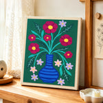 Colourful flowers in striped blue vase punch needle artwork displayed on a table