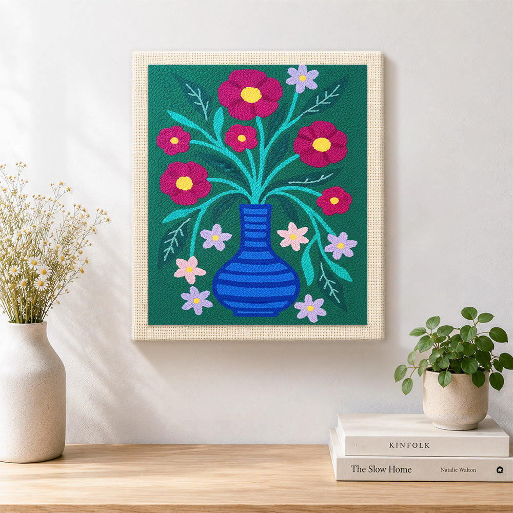 Finished colourful flowers in striped blue vase artwork displayed on a wall