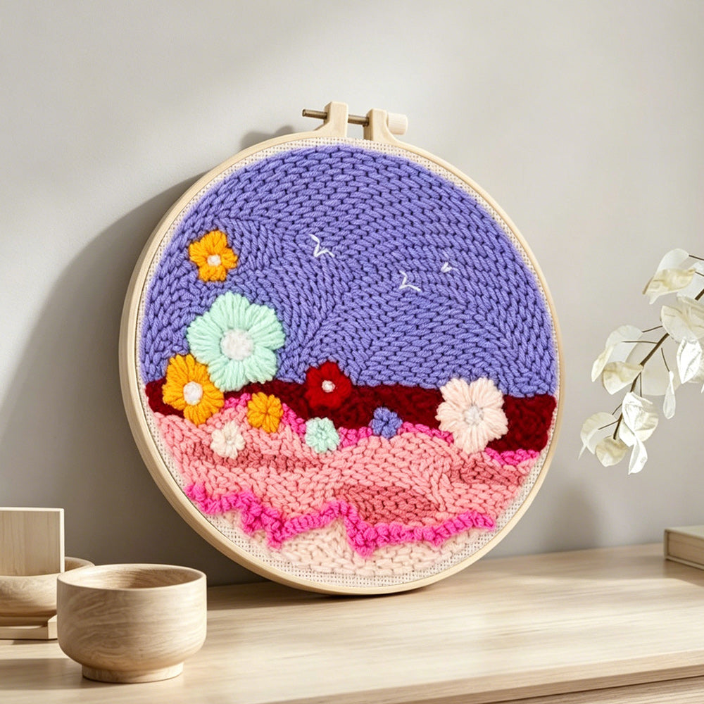 Colourful flowers on purple sky punch needle artwork displayed on a table