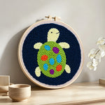 Colourful little turtle punch needle artwork displayed on a table