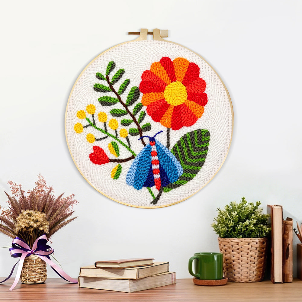 Finished colourful moth and large flower artwork displayed on a wall